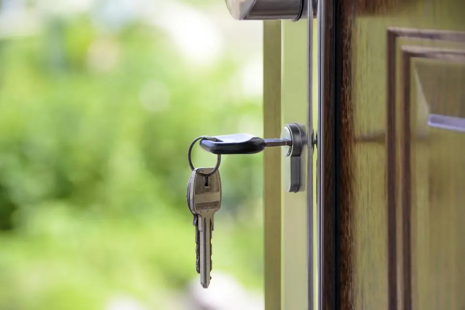 A set of keys hanging from a front door lock