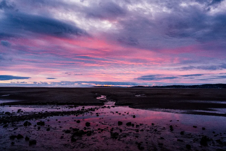 A rocky beach under a purple evening sky